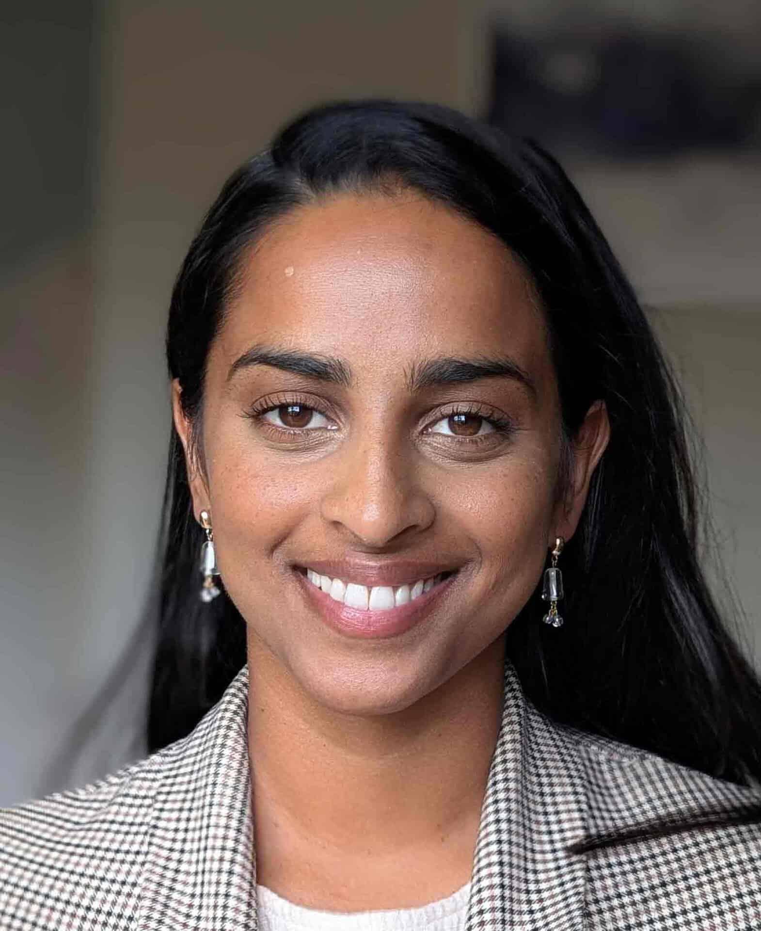 Smiling woman with dark hair and earrings, representing Jessica George at Equana Minds.