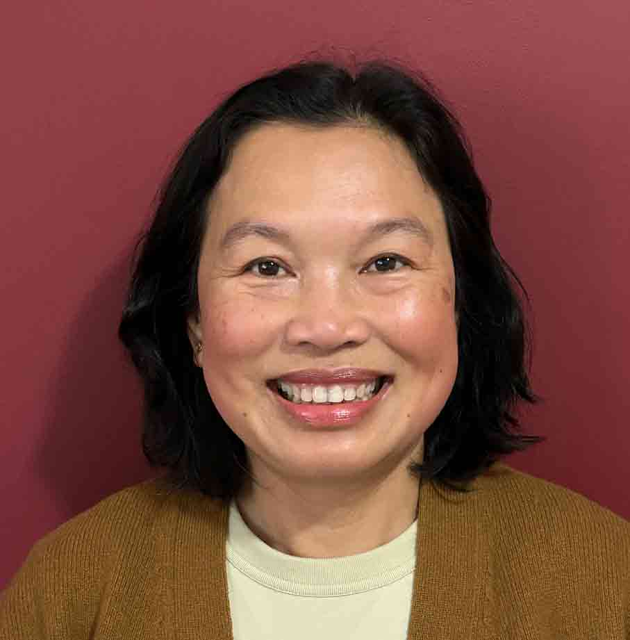 Smiling woman with shoulder-length black hair against a red background, representing Equana Minds.