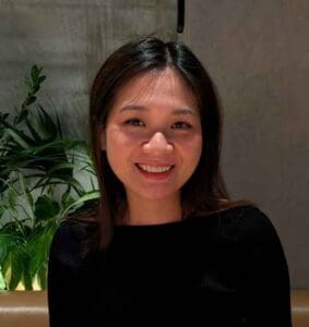 Smiling woman with dark hair in a black top at Equana Minds.