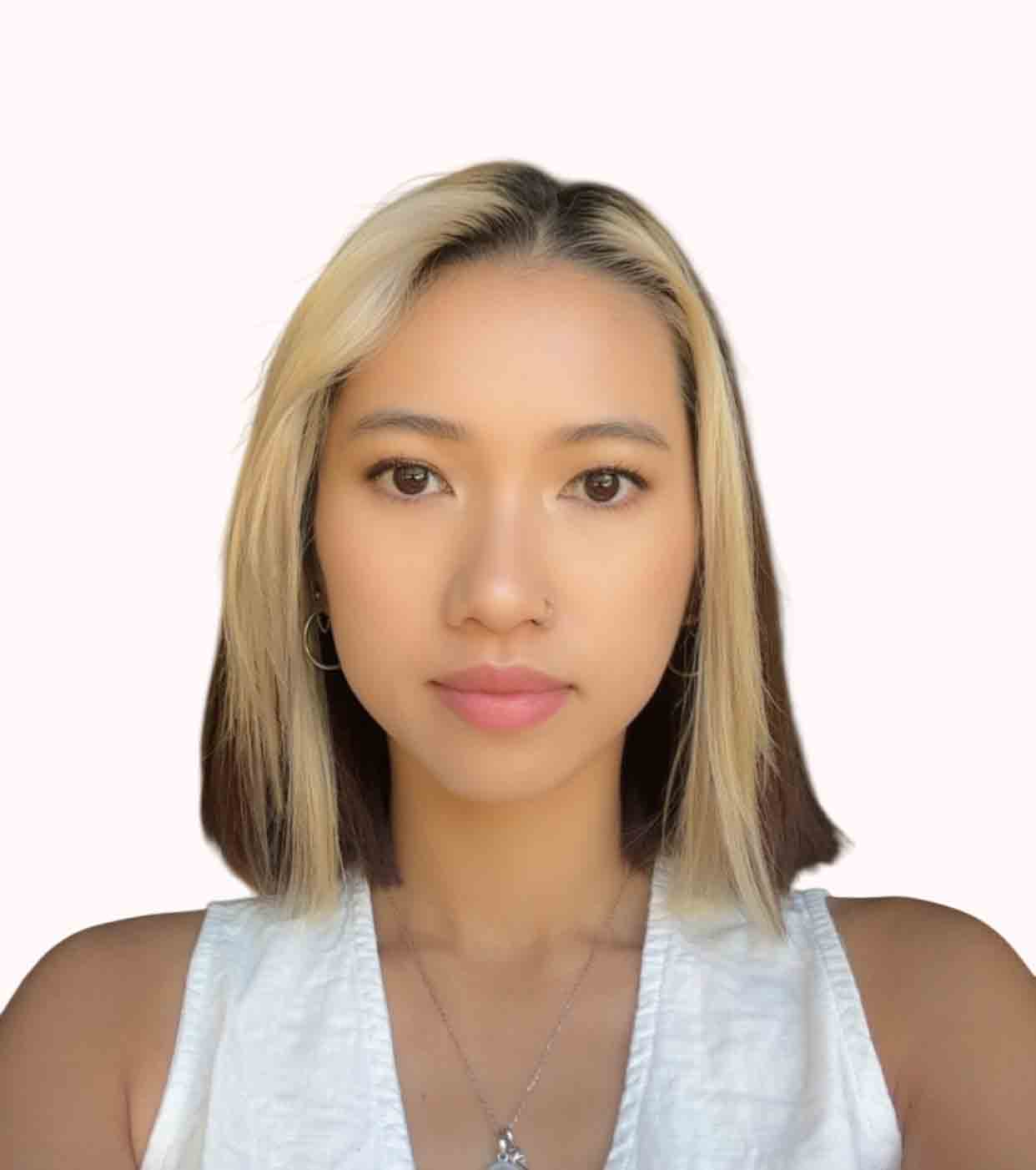 Portrait of a young woman with blonde and dark hair, wearing a white top and silver necklace.