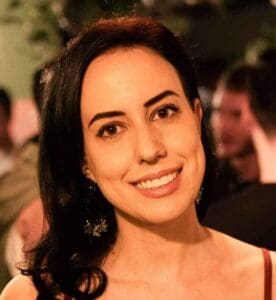 Smiling woman with dark hair and earrings at an event for Equana Minds.