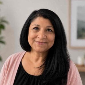 Portrait of a woman with long black hair smiling indoors at Equana Minds.